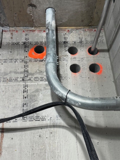 Conduit PVC traversant une dalle entre les carottages de précision
